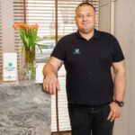 Mężczyzna w czarnej koszulce obok lady recepcyjnej