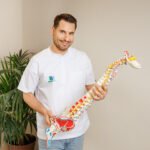 fizjoterapeuta trzymający model kręgosłupa