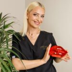 Pani kosmetolog w rękawiczkach trzyma model ust