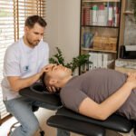 Fizjoterapeuta dotyka głowy pacjenta